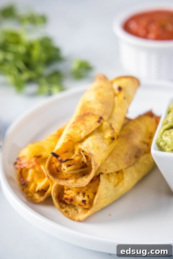baked chicken taquitos on a white plate