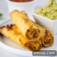 close up of crispy chicken taquitos on a plate with guacamole