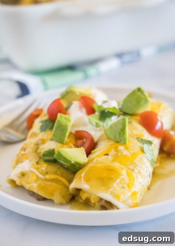 Ultimate Breakfast Enchiladas 5 white plate with 2 enchialdas topped with avocado