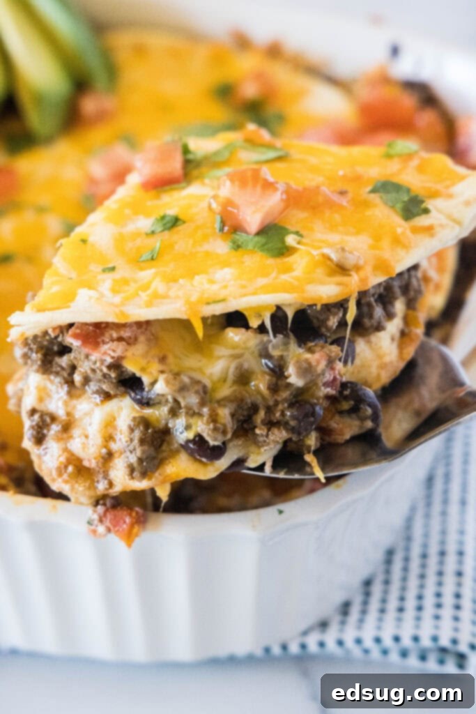 Burrito Bake 2 A delicious slice of Burrito Casserole on a spatula, ready to be served from a baking dish.