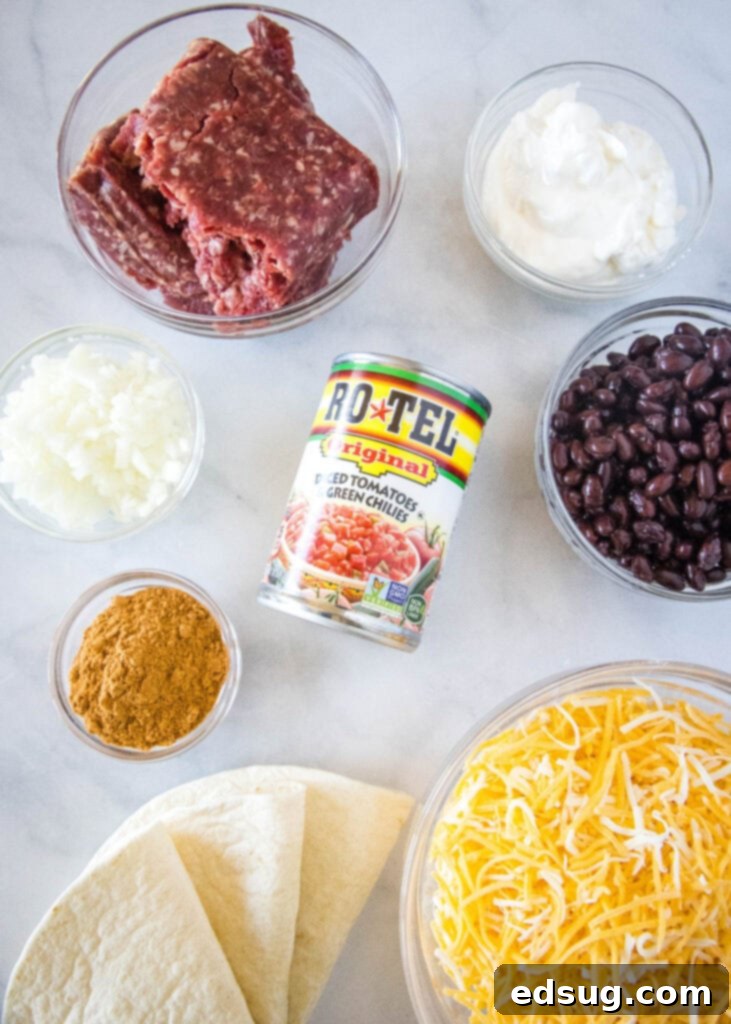 Burrito Bake 3 Ingredients laid out on a counter for making Burrito Casserole, including ground beef, tortillas, beans, and cheese.