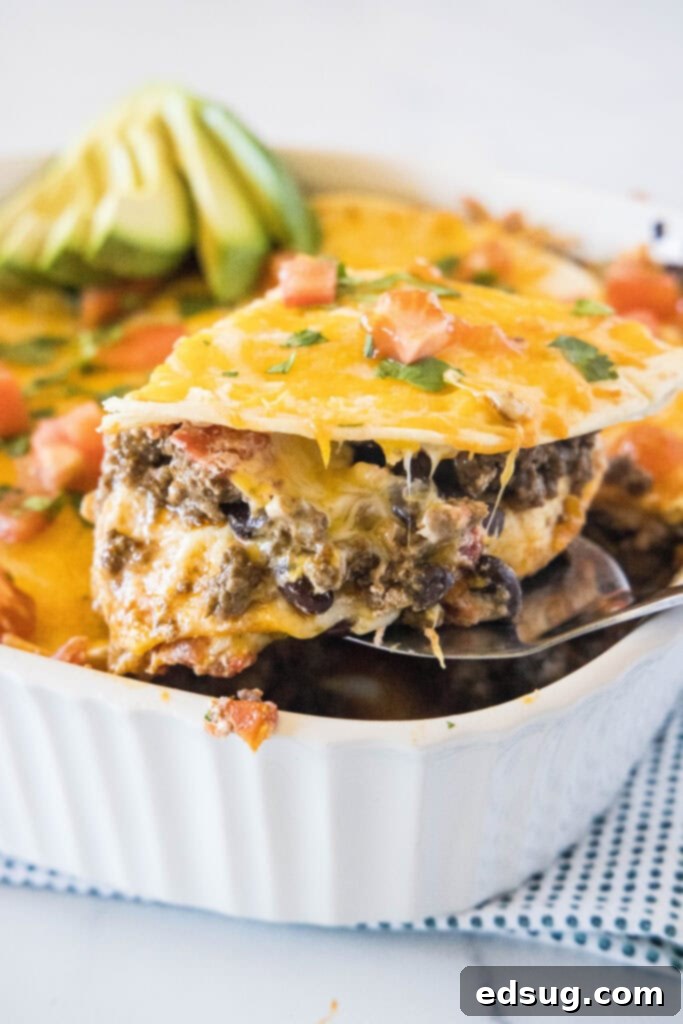 Burrito Bake 6 A perfectly cut slice of Burrito Casserole lifted out of the pan with a spatula.