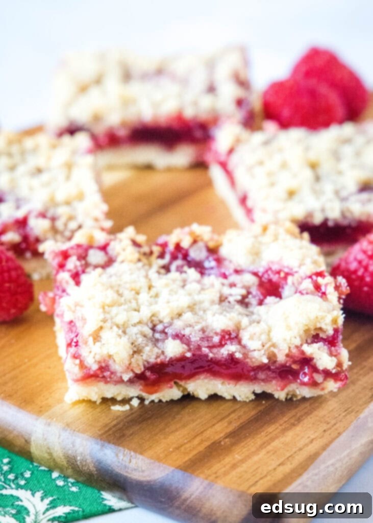 Luscious Raspberry Crumble Bars 6 sliced raspberry crumble bars on a cutting board, ready to serve