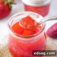 close up of jelly on a spoon over a jar