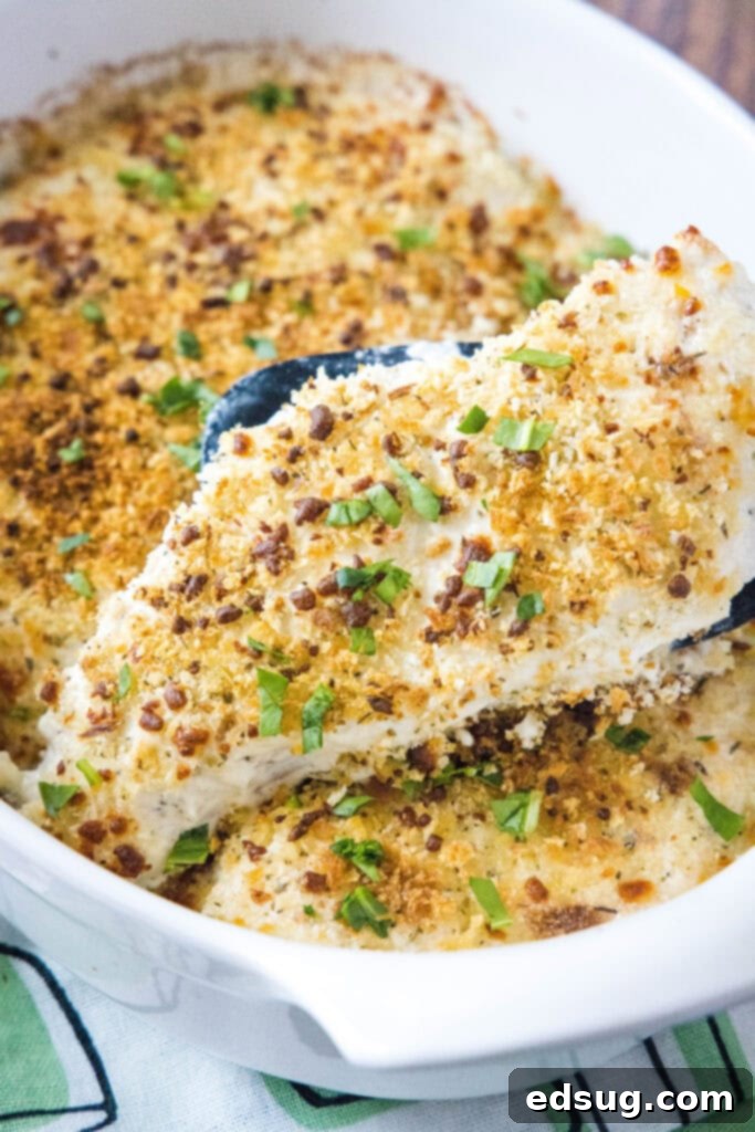 Golden Baked Caesar Chicken 2 scooping baked chicken out of baking dish