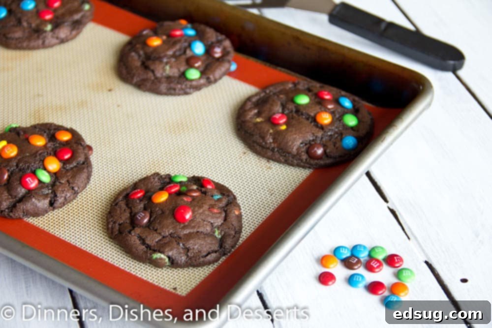 Easy Chocolate M&M Cookie Recipe Freshly baked chocolate M&M cookies cooling on a baking pan