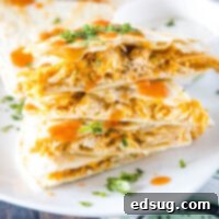 Spicy Buffalo Chicken Quesadilla 2 A stack of slices of buffalo chicken quesadillas on a plate, topped with cilantro