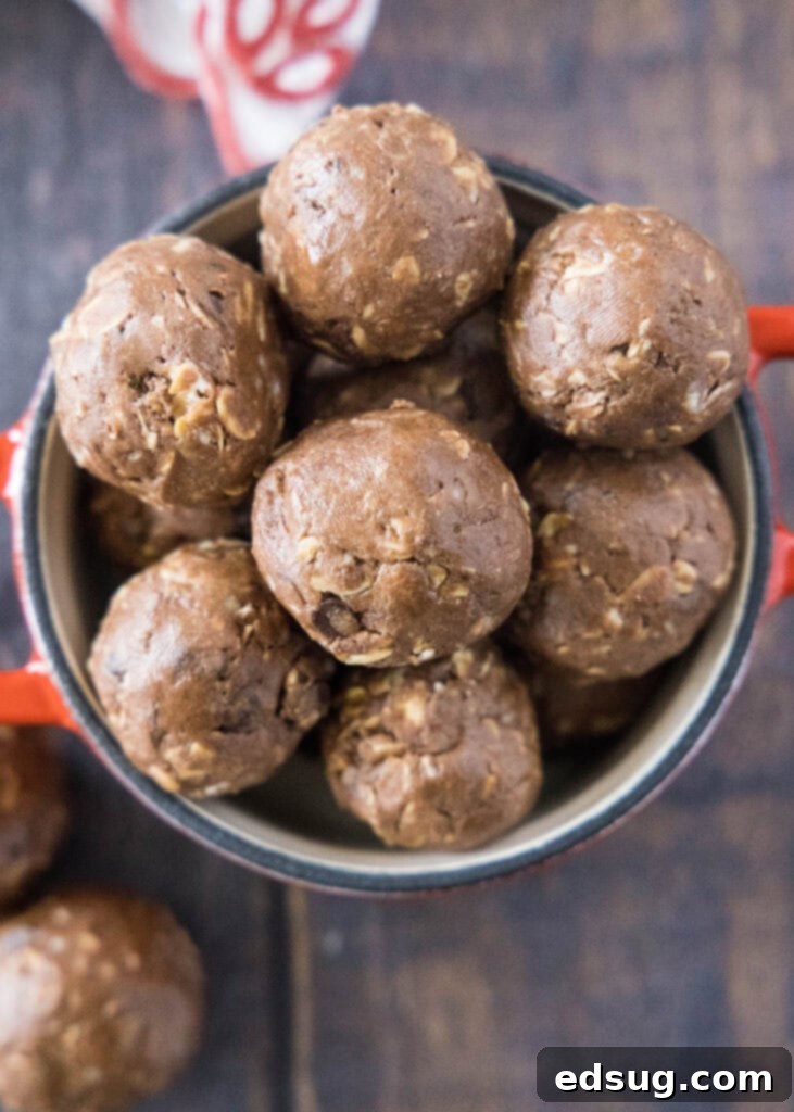 Power Chocolate Protein Bites 5 A top-down view of a stylish red bowl overflowing with perfectly crafted chocolate protein bites, showcasing their rich color and inviting texture.