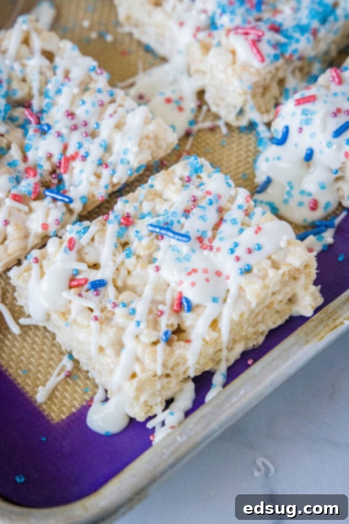 krispie treats on a baking tray with chocolate and sprinkles