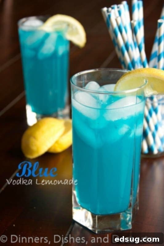 Refreshing Blue Vodka Lemonade Cocktail for Parties Vibrant blue vodka lemonade cocktail in a tall glass with a lemon wedge and ice