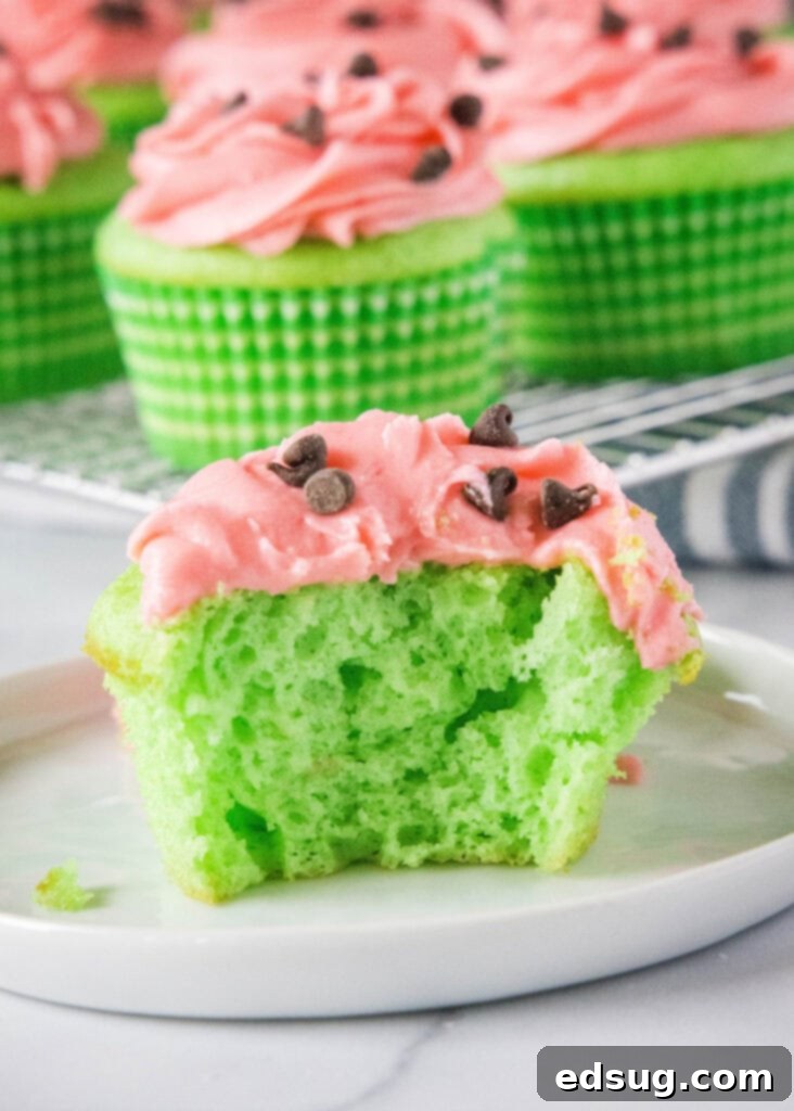 Watermelon Wonder Cupcakes 6 A watermelon cupcake cut in half, revealing the green cake and pink frosting layers