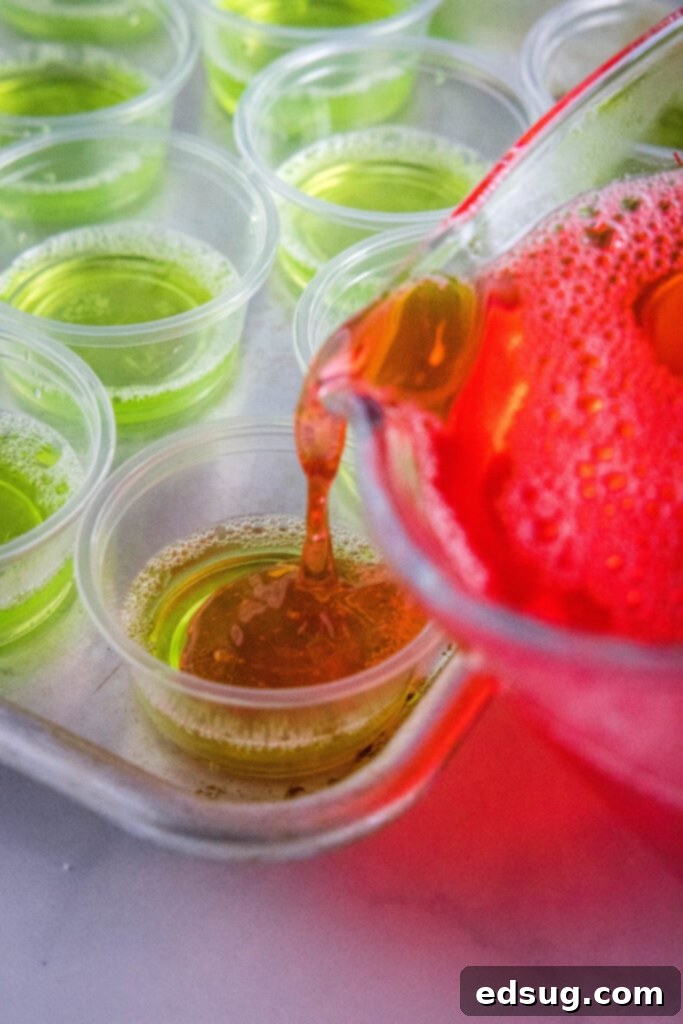 Watermelon Wobblers 5 pouring red jello over green layer