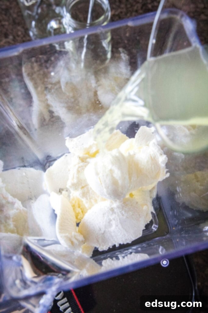 Chick-fil-A's Creamy Lemon Bliss 4 Pouring freshly made lemonade into a blender filled with scoops of vanilla ice cream, ready to be blended.