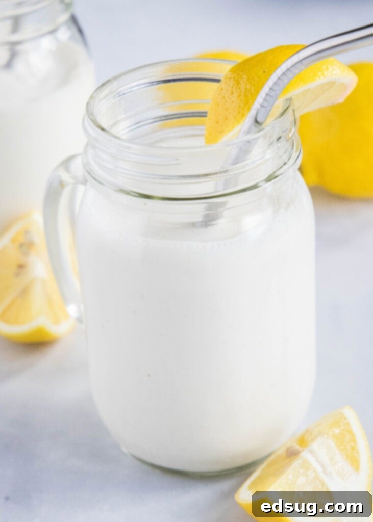 Chick-fil-A's Creamy Lemon Bliss 5 A tall glass of frosted lemonade with a straw and lemon slice, inviting and ready to drink.