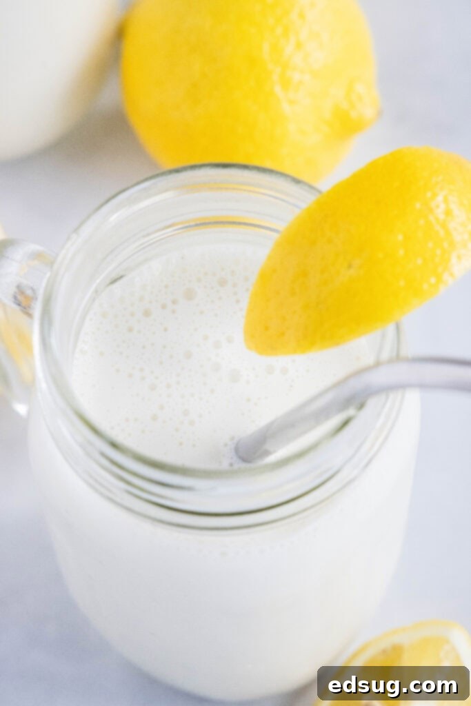 Chick-fil-A's Creamy Lemon Bliss 6 A close-up of a perfectly blended frosted lemonade in a glass, garnished with a vibrant lemon slice.