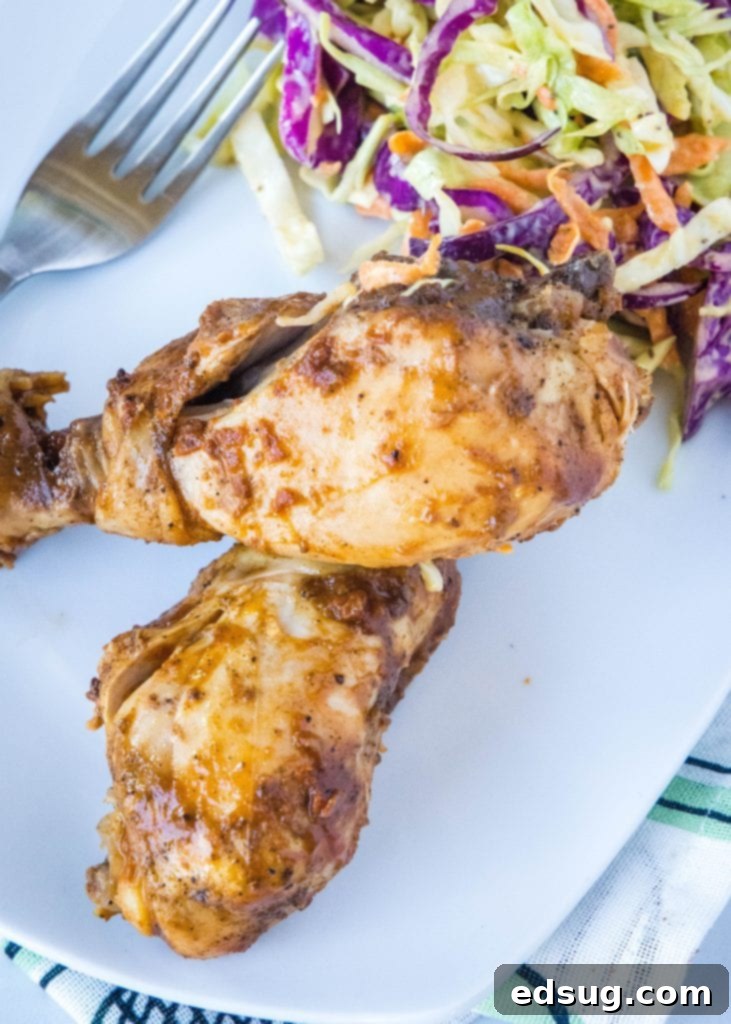 Fall-Off-The-Bone Slow Cooker Drumsticks 7 Overhead shot of a white plate with slow cooker chicken drumsticks and a side of coleslaw.