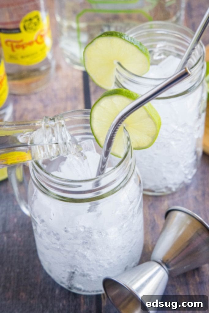 pouring topo chico sparkling water into a glass to make ranch water