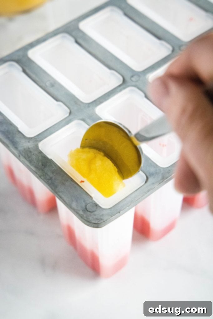 spooning peach puree into popsicle molds