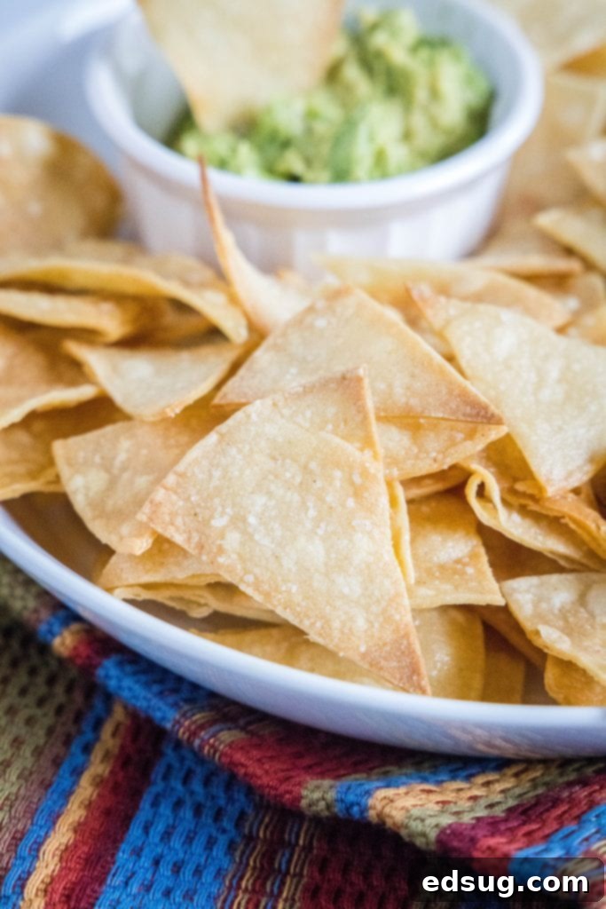 From Scratch Tortilla Chips 3 Bowl of homemade tortilla chips served with a side of fresh guacamole, ready for dipping.