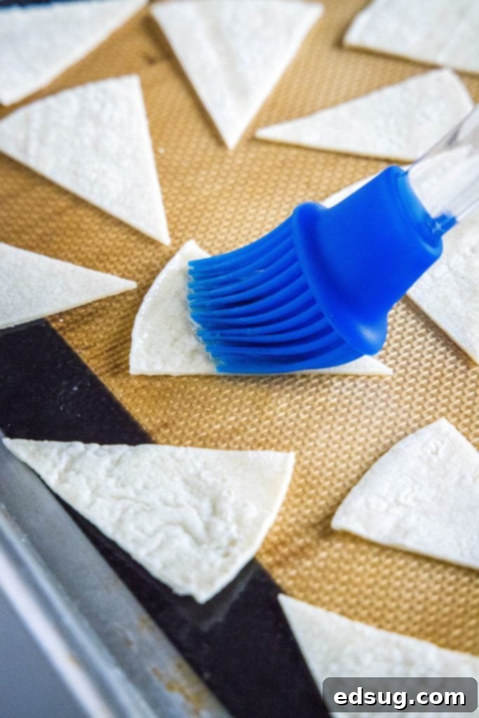 From Scratch Tortilla Chips 6 Homemade tortilla chips arranged on a baking sheet, lightly brushed with oil and seasoned, ready for baking.
