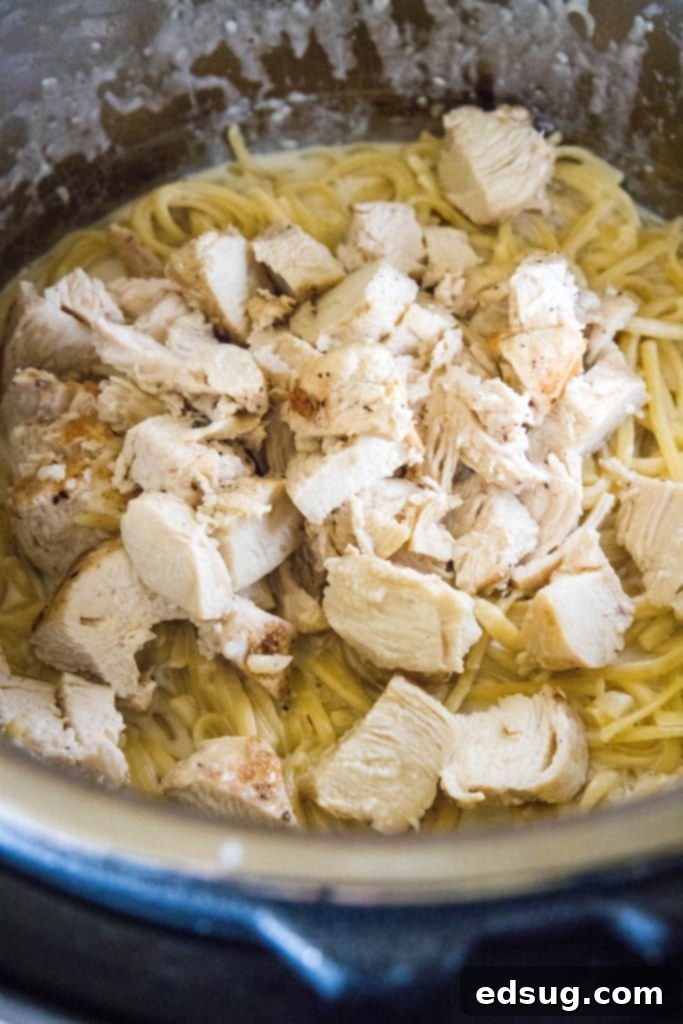 One Pot Wonder Chicken Alfredo 5 adding sliced chicken back to the creamy alfredo pasta in the instant pot