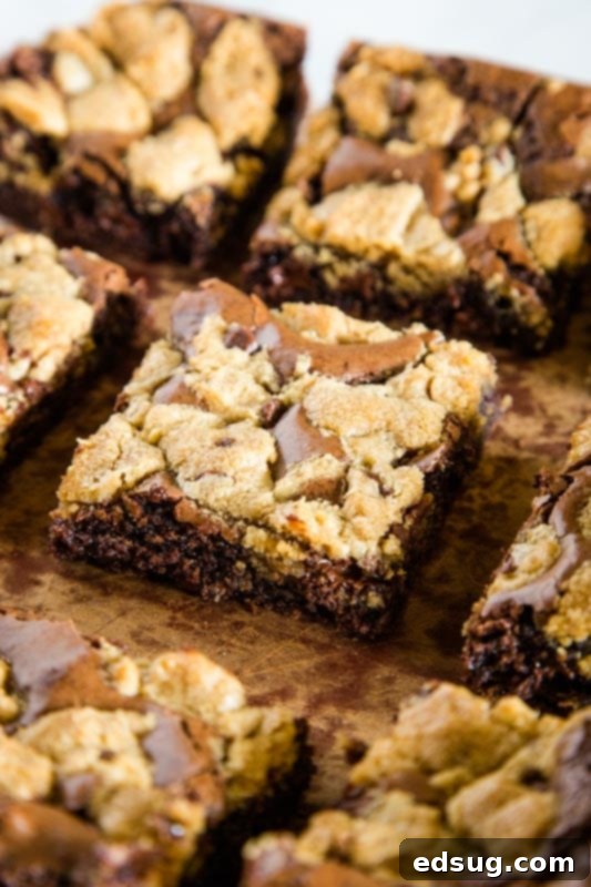 Unbaked Brookie bars showing a layer of brownie batter topped with dollops of chocolate chip cookie dough in a baking pan.