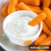 cropped close up dipping a carrot in ranch