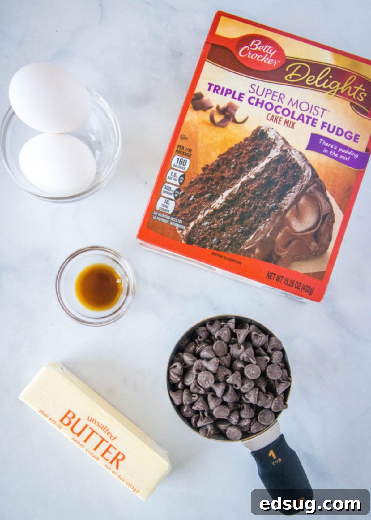 These 30-minute cake mix brownies only use 5 ingredients, and they're moist, soft, and packed full of chocolate flavor Overhead view of the simple ingredients for cake mix brownies: a box of chocolate cake mix, a stick of melted butter in a bowl, a bowl with two eggs, a bottle of vanilla extract, and a measuring cup of semi-sweet chocolate chips