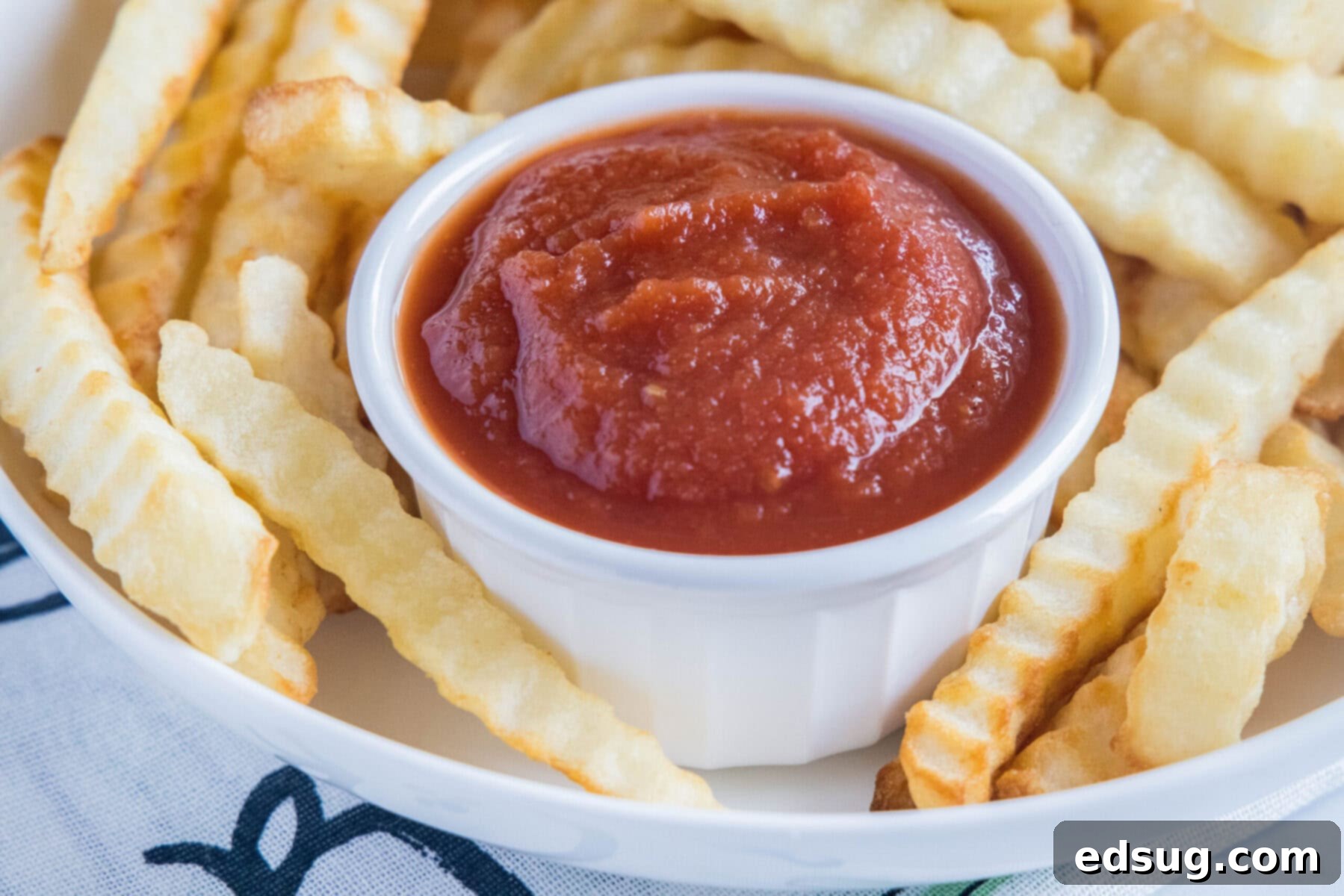 Homemade ketchup is tangy, salty, smooth, and so much better than the store-bought kind. Plus, it's easy to make and takes less than an hour. A small ramekin filled with rich, red homemade ketchup, perfectly poised among a scattering of golden, crispy French fries.