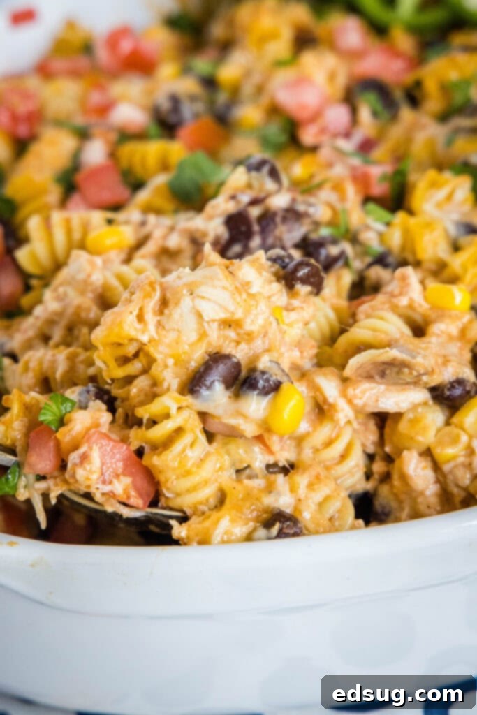 Zesty Southwest Chicken Casserole 6 A serving of hot and bubbly Fiesta Chicken Casserole being scooped from the pan, highlighting its appealing layers and cheesy goodness.