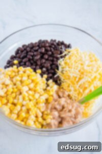 Zesty Southwest Chicken Casserole 10 chicken, corn, black beans, and cheese in a mixing bowl