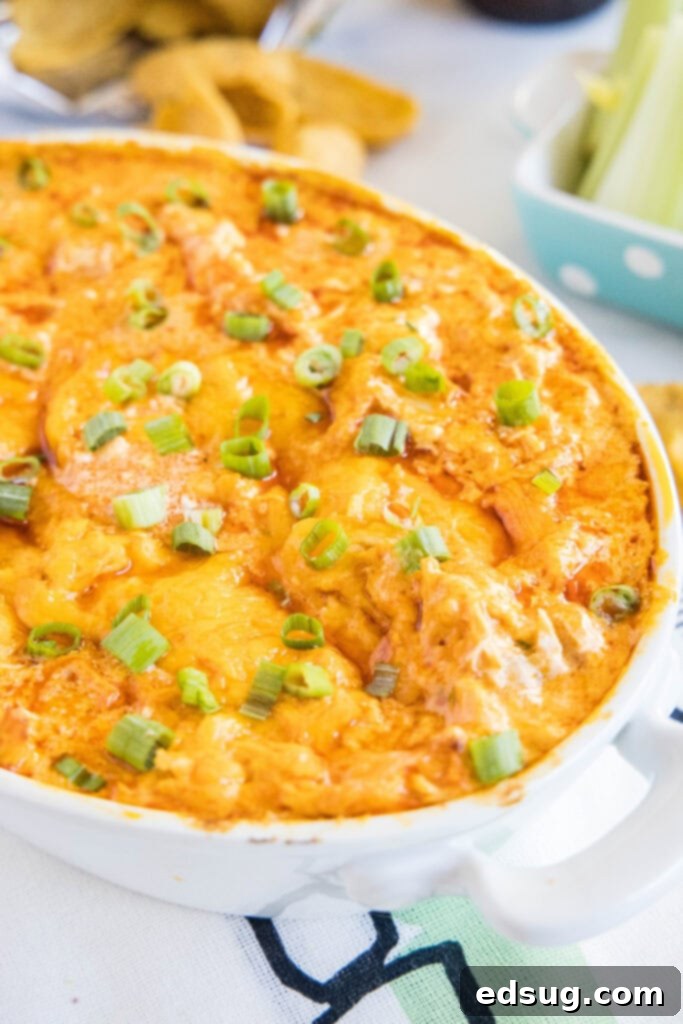 Ultimate Instant Pot Buffalo Chicken Dip 2 cheesy buffalo chicken dip in a serving dish, garnished with fresh green onions