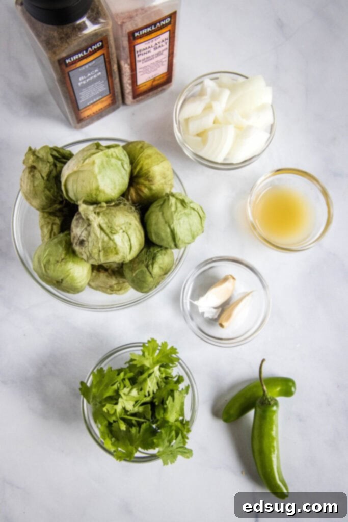 A vibrant selection of fresh ingredients laid out on a cutting board, including tomatillos, garlic cloves, onions, serrano peppers, and cilantro, all ready to be transformed into homemade salsa verde.