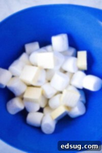 marshmallows and pieces of butter in a mixing bowl