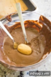 dipping peanut butter footballs in melted chocolate