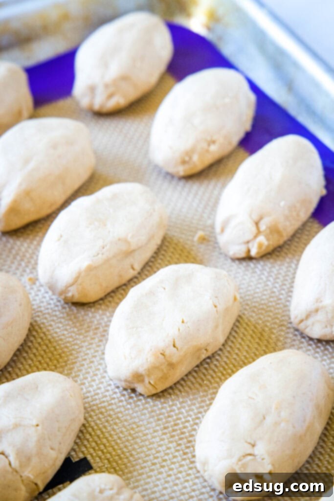 Partially shaped peanut butter footballs neatly arranged on a baking tray, ready for chilling
