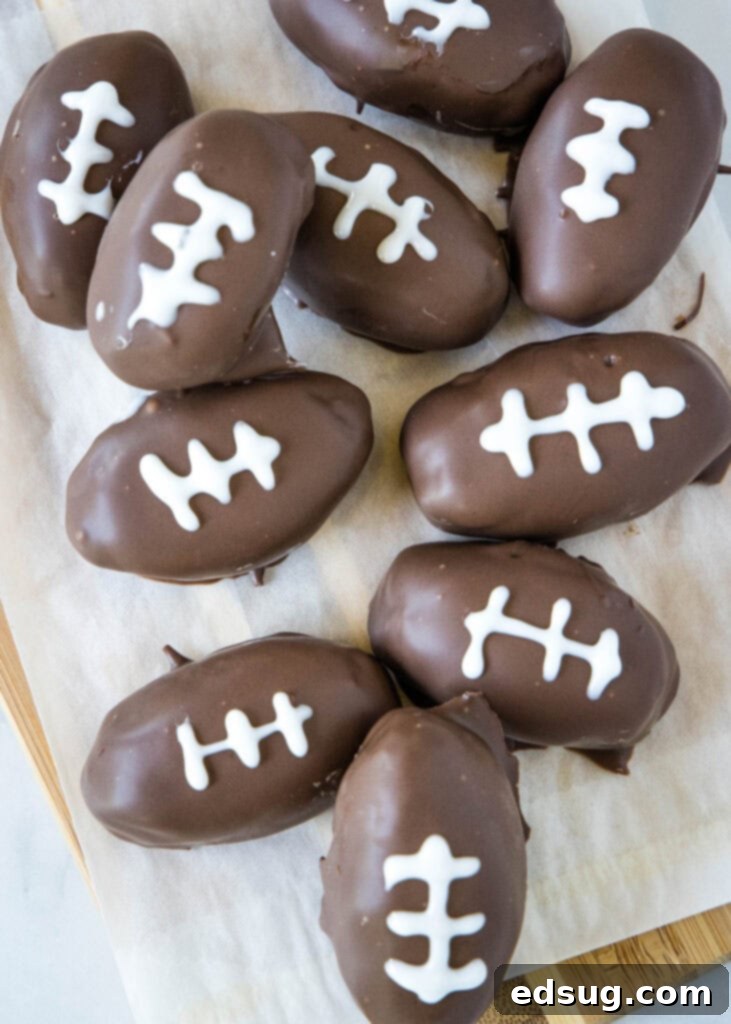 An overhead view of a tray filled with freshly made chocolate covered peanut butter footballs