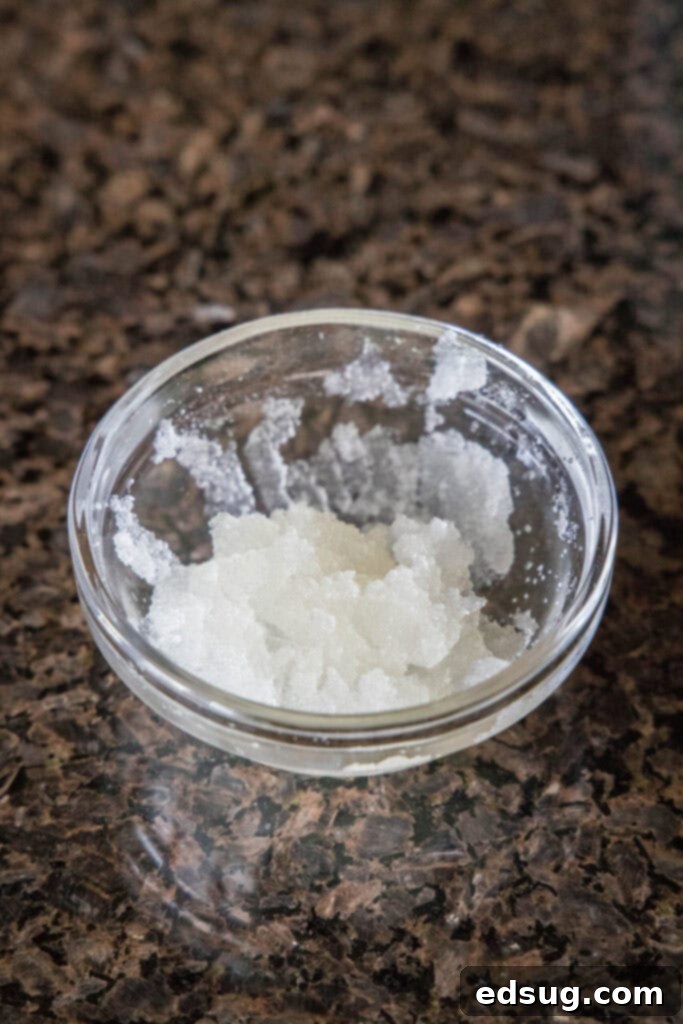 Bloomed Gelatin Mixture A bowl of water mixed with gelatin powder that has solidified into a spongy mass, indicating it has bloomed.