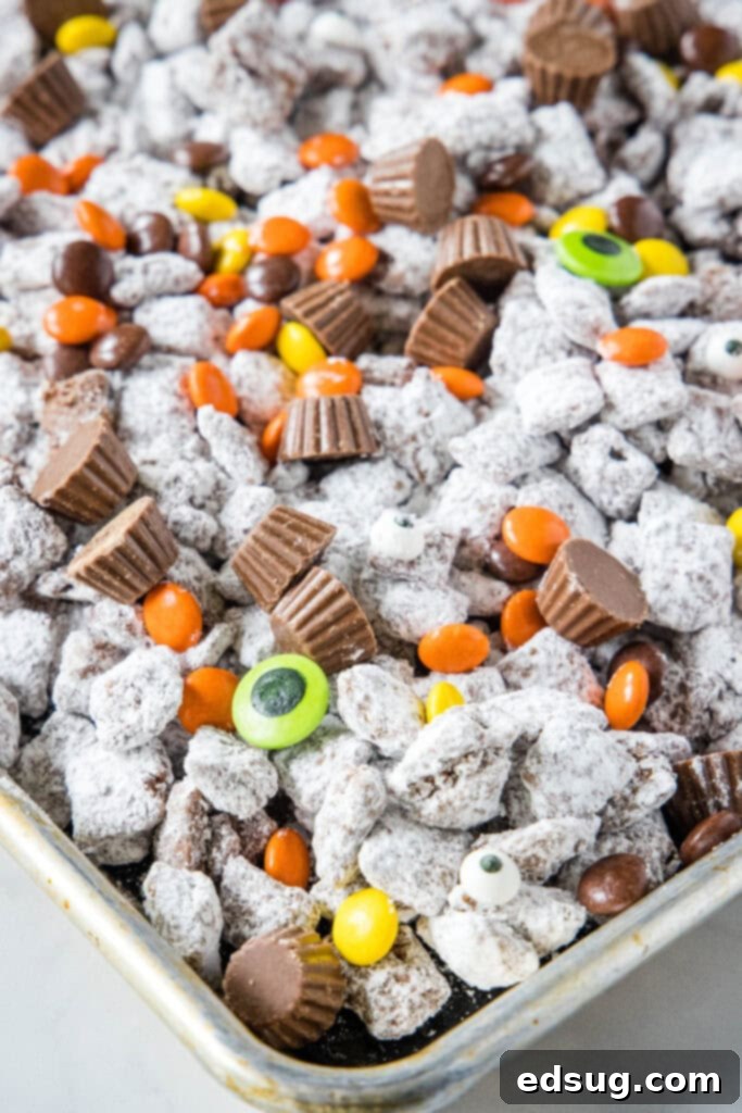 Spooky Halloween Muddy Buddies 2 halloween puppy chow on baking tray, ready to serve