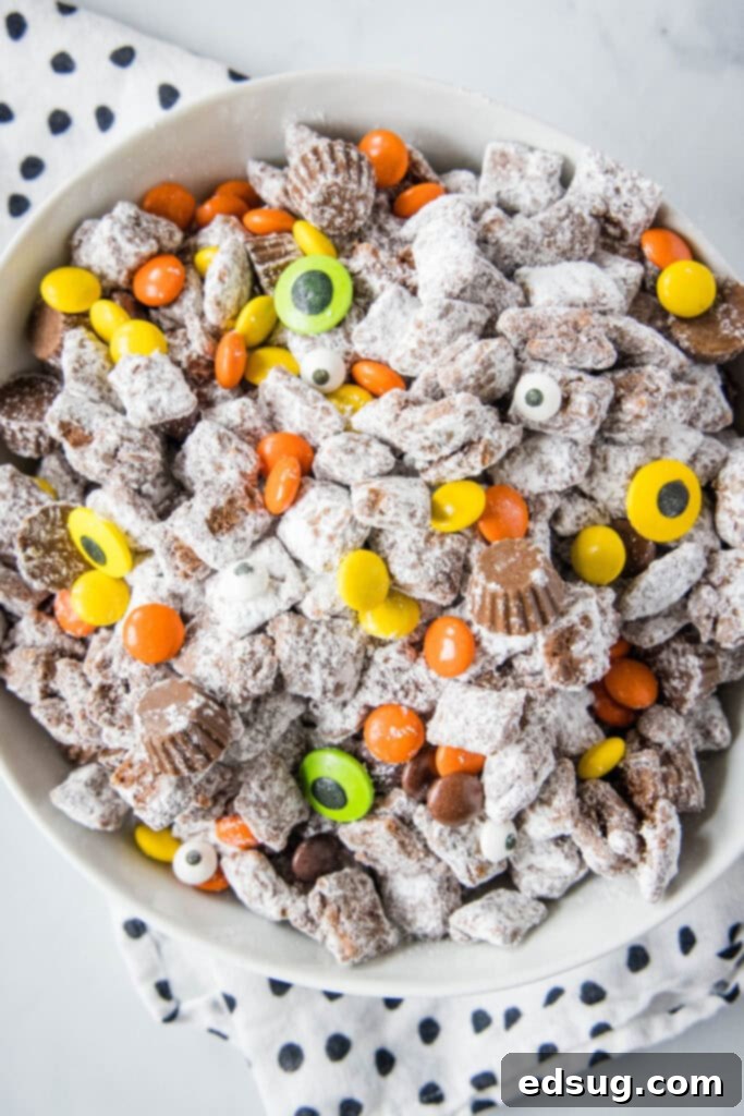 Spooky Halloween Muddy Buddies 5 looking down on a bowl of halloween muddy buddies with candy eyes
