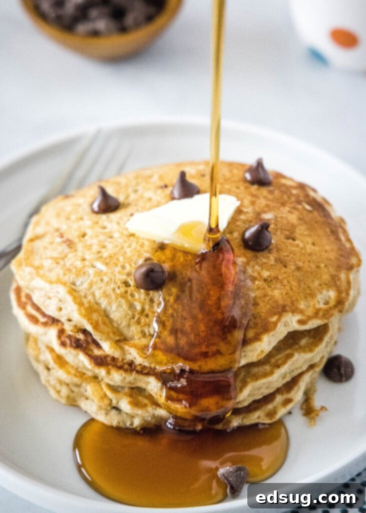 Wholesome Oat Pancakes 7 pouring syrup on a stack of oatmeal pancakes, making them look irresistible
