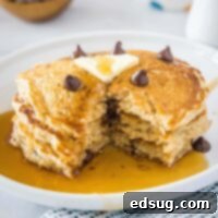 Wholesome Oat Pancakes 9 cropped close up pancakes with a bite missing on a white plate, showcasing the fluffy texture and optional chocolate chips
