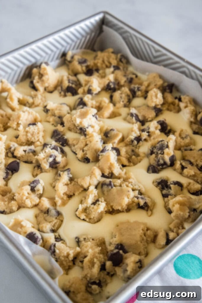 Choc-Chip Cheesecake Dream Bars 4 cookie dough sprinkled ontop of cheesecake mixture in a baking dish