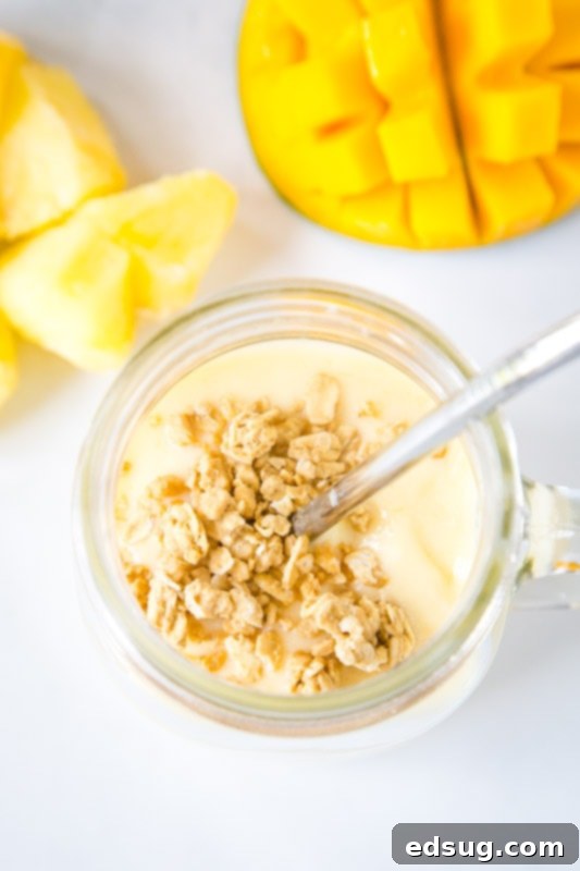Tropical Mango Pineapple Smoothie 3 close up of smoothie in a glass with granola on top