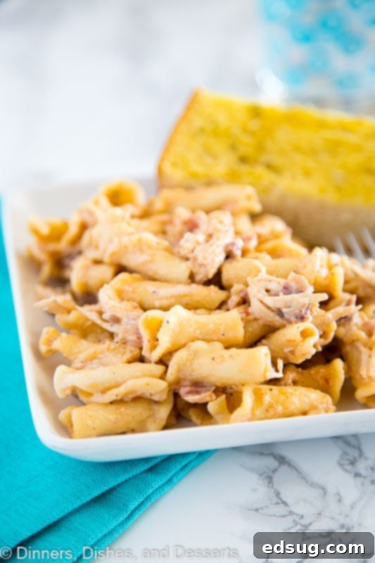 Smokey Garlic Chicken Pasta - A creamy chicken pasta dish with a tons of flavor. A little smokey, a little peppery, and so good! Smokey Garlic Chicken Pasta served in a bowl with a side of garlic bread