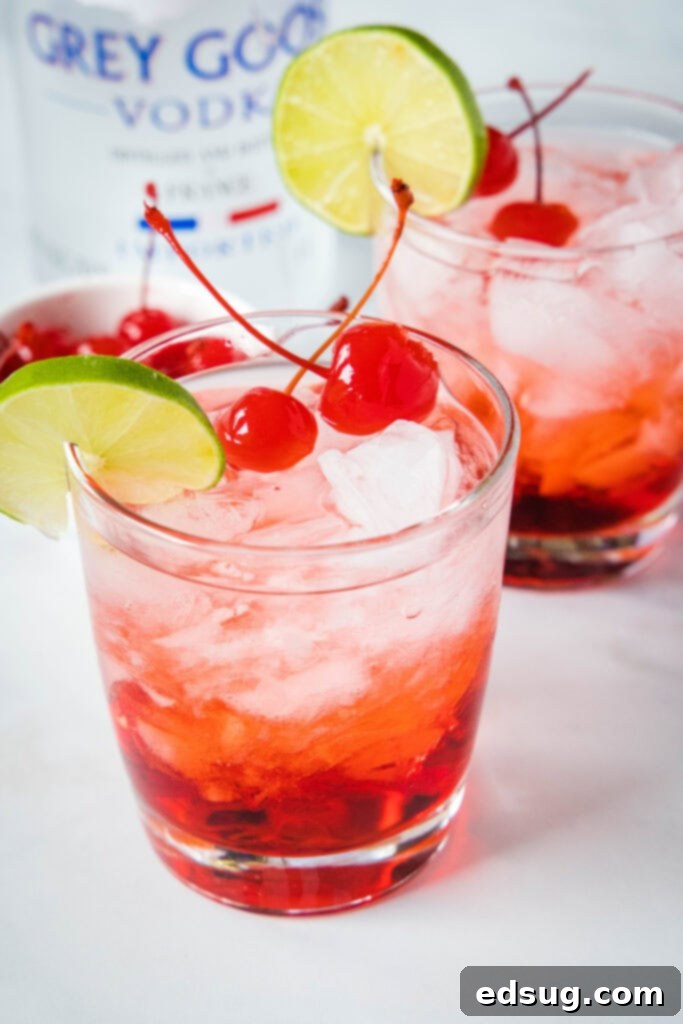 dirty shirley in a glass with cherries and lime