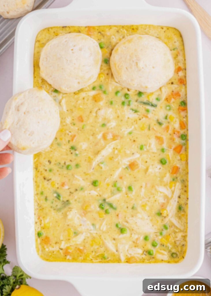 adding partially cooked biscuits to the top of the casserole