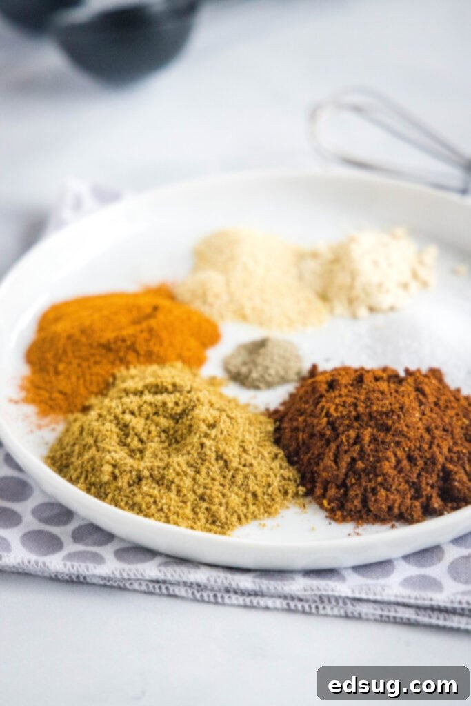 This 5-minute fajita seasoning is spicy, smoky, salty, and loaded with cumin and garlic, perfect for shrimp, chicken, or steak fajitas. A round plate with piles of salt, pepper, garlic powder, onion powder, paprika, ground cumin, and chili powder