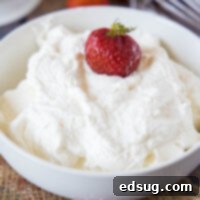 close up bowl of whipped cream with a strawberry in it