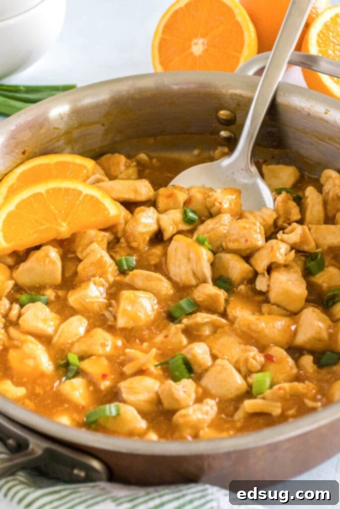 Zesty Orange Chicken 2 A serving of homemade orange chicken being scooped from a skillet, ready to be enjoyed.